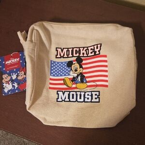 cream canvas zip pouch featuring a graphic of Mickey Mouse in front of a United